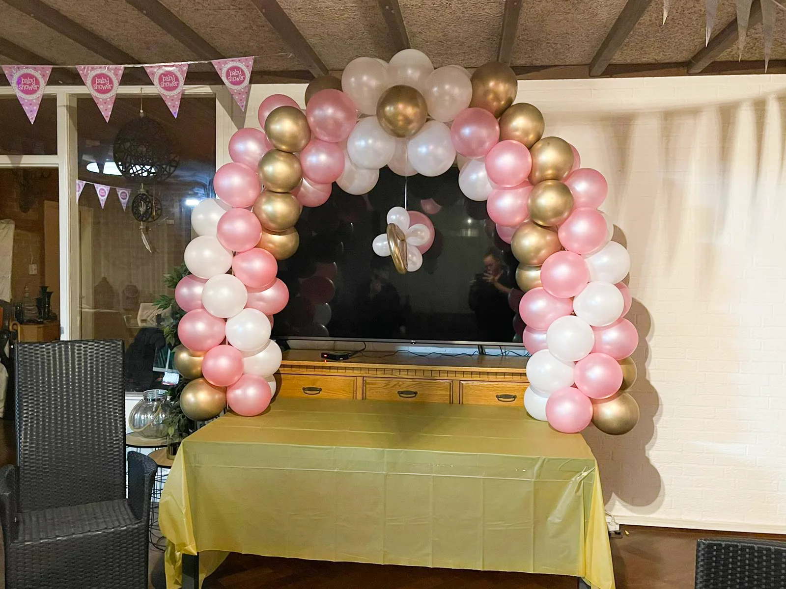 Roze, witte en gouden ballonnenboog voor een babyshower