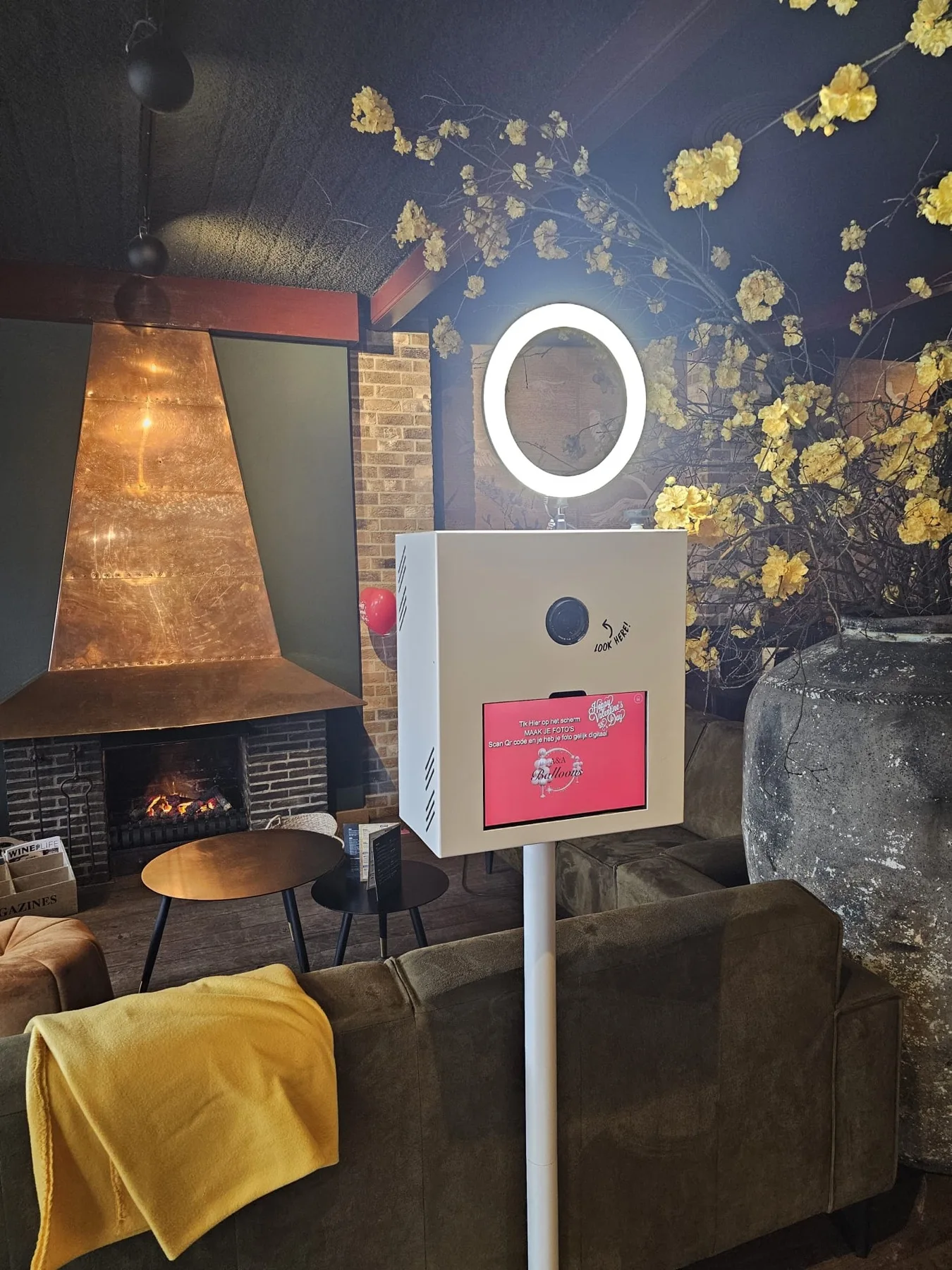 Witte photobooth van A&A Balloons met touchscreen, camera en ringlamp op een feestlocatie