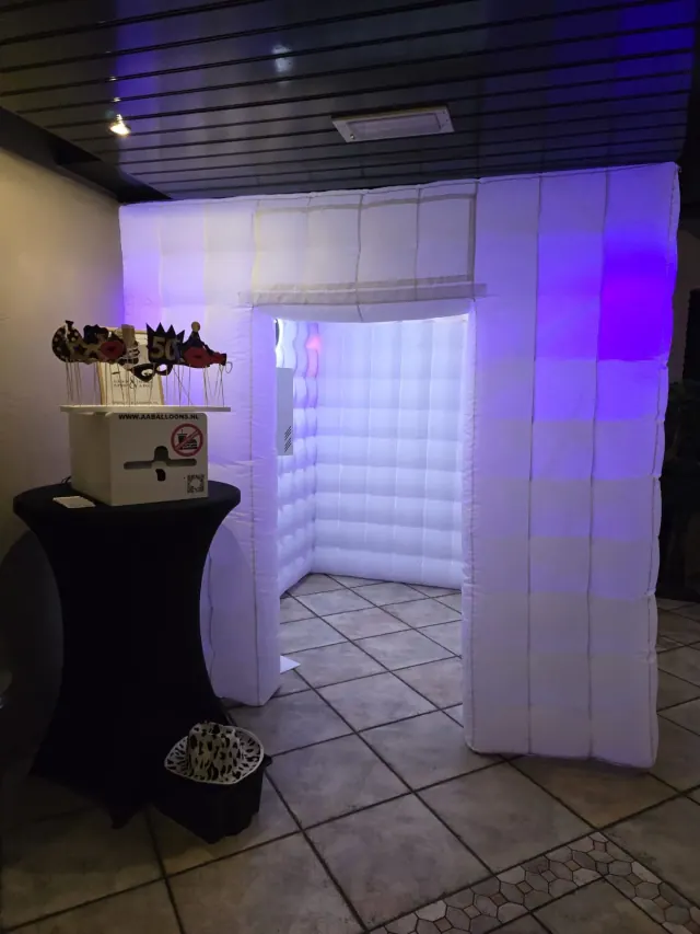 Photoboothtent met verlichte binnenzijde en feestelijke props