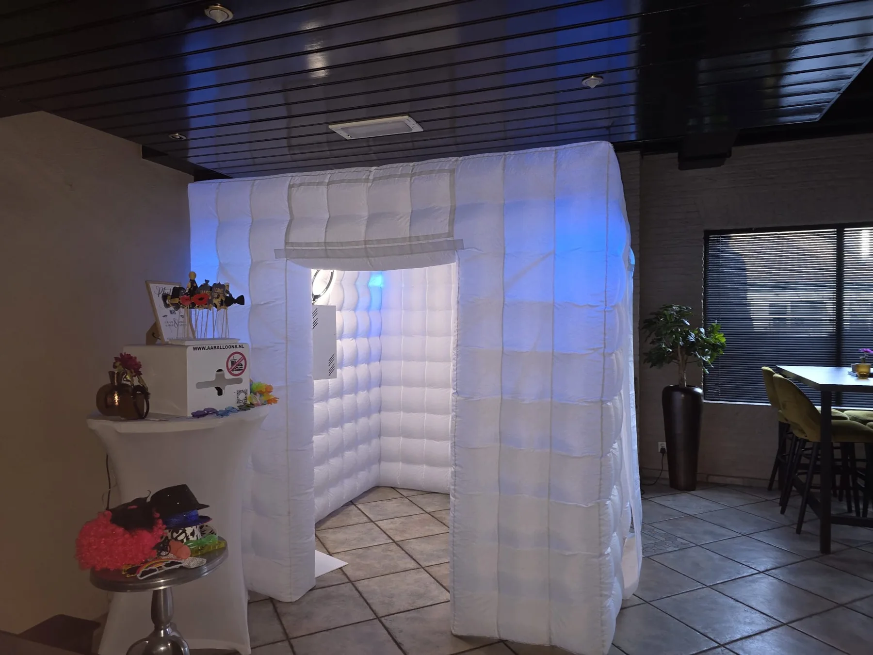 Witte opblaasbare photoboothtent opgesteld op een feestlocatie